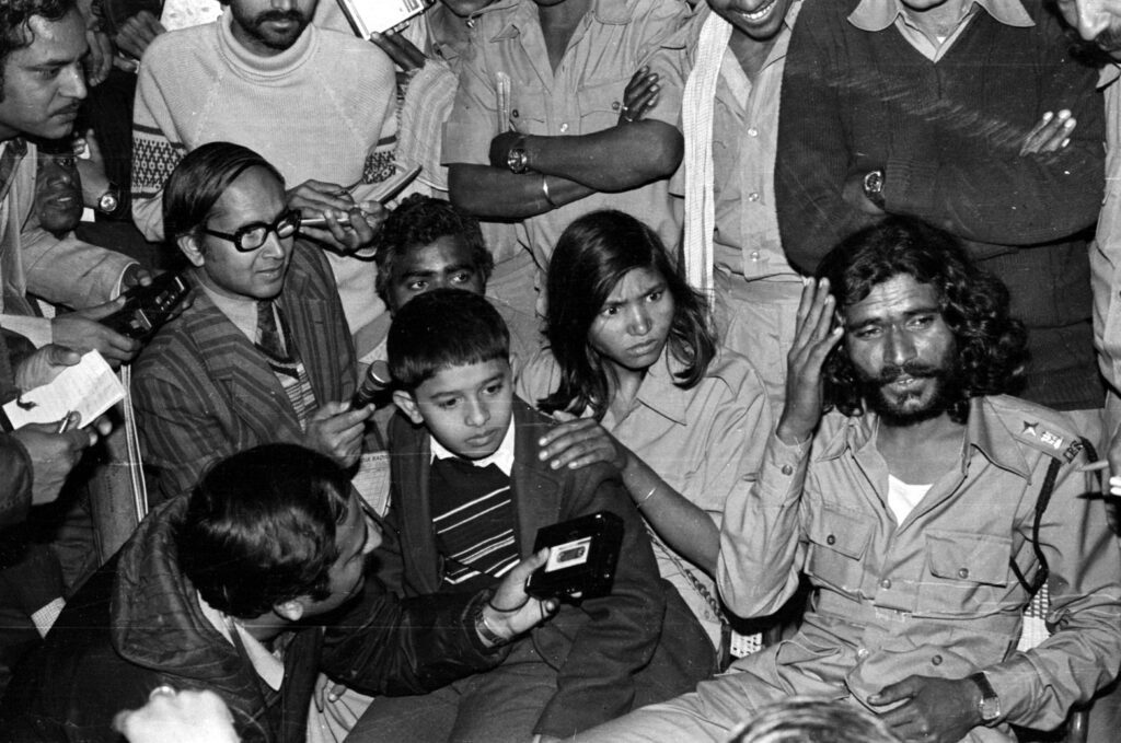 Phoolan Devi in Jail with Journalists - 1983 Phoolan Devi seated in jail, surrounded by journalists and photographers, 1983