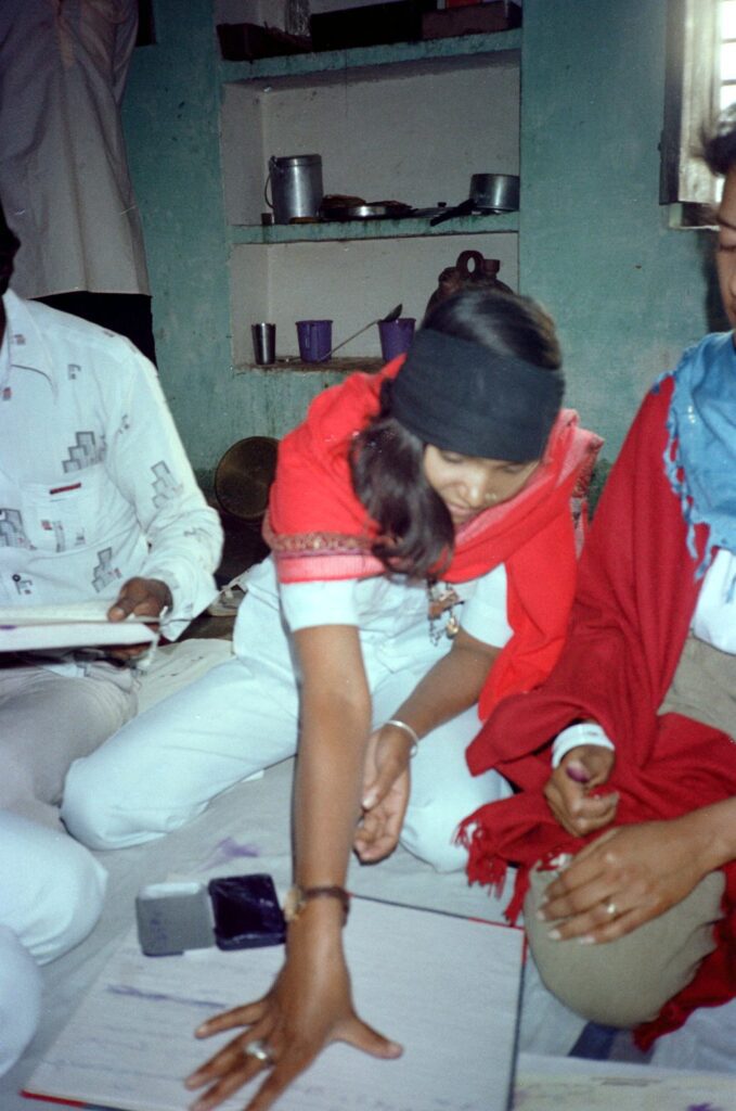Phoolan Devi pressing her thumbprint onto a journal page as her signature, 1983